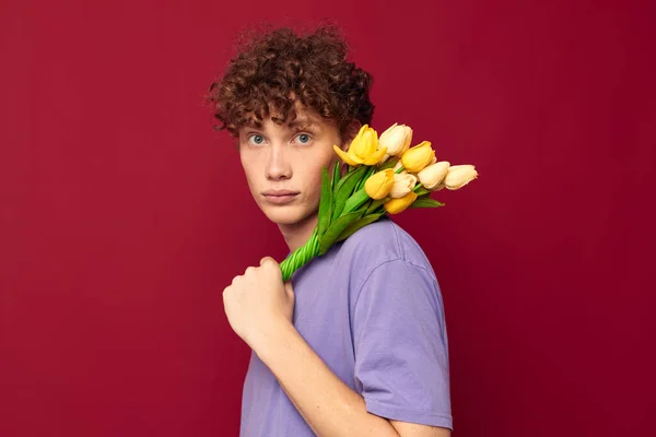 Un hombre joven pelo rojo en el ramo de ropa casual de flores regalo fondo rojo inalterado — Foto de Stock