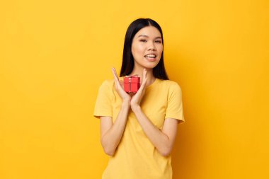 Güzel esmer küçük kırmızı hediye kutusu eğlenceli sarı arka plan değiştirilmemiş