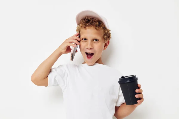 Lindo chico qué tipo de bebida es el teléfono en la mano comunicación luz fondo inalterado — Foto de Stock
