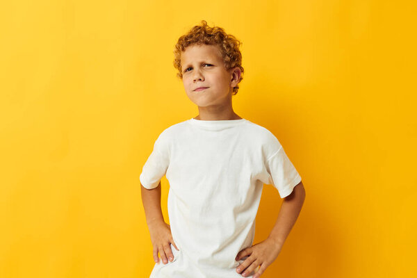 веселый мальчик в белой футболке с желтым фоном детства