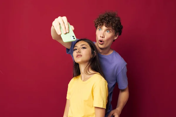 Giovane uomo e ragazza in t-shirt colorate con un telefono Stile giovanile — Foto Stock