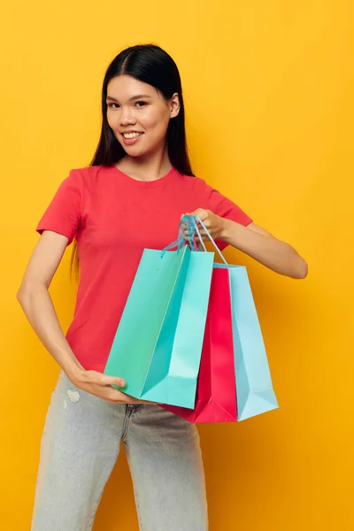 다양 한 색깔의 쇼핑백을 갖고 있는 젊은 아시아 여성을 아무런 변화 없이 공격하는 장면 — 스톡 사진