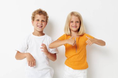 Pozitif erkek ve kız kıyafetlerinin fotoğrafı duygusal poz veren stüdyo değiştirilmemiş arka plan