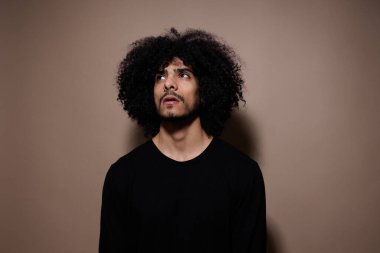 Kıvırcık saçlı, modaya uygun, modern yaşam tarzı değişmemiş bir adam.