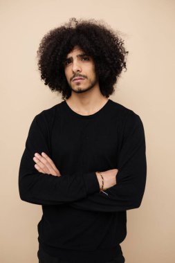 Kıvırcık saçlı, stil sahibi sıradan giyimli, değişmemiş yaşam tarzı olan bir adam.