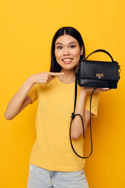 Vacker kvinna i gul t-shirt svart väska poserar mode — Stockfoto