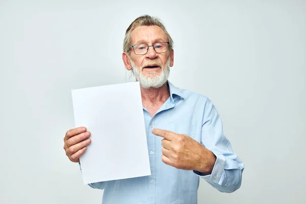 Портрет пожилого человека в синей рубашке и очки белый лист бумаги неизменным — стоковое фото