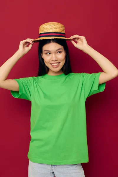 Encantadora jovem mulher asiática em uma camiseta verde gesticulando com as mãos divertidas modelo de estúdio inalterado — Fotografia de Stock