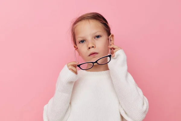 Portrait d'enfant souriant heureux fille dans un pull blanc et des lunettes fond isolé — Photo