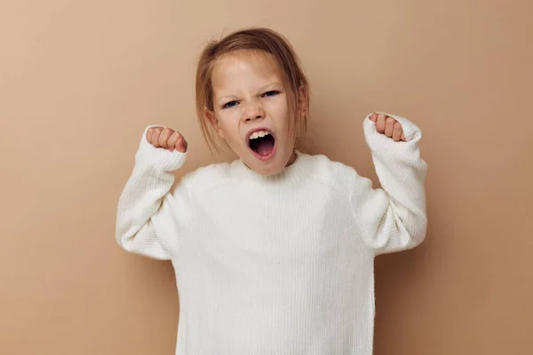 Słodkie dziewczyna w biały sweter pozowanie strony gesty dzieciństwo bez zmian — Zdjęcie stockowe
