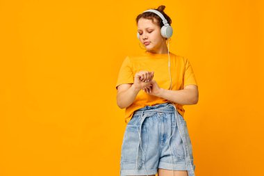 Kulaklık takan güzel bir kadın. Kot şortu, yakın çekim duyguları. Yaşam tarzı değişmemiş.