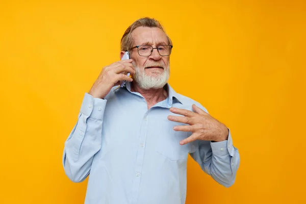 Retrato de hombre mayor feliz en una camisa azul y gafas hablando en el teléfono vista recortada —  Fotos de Stock