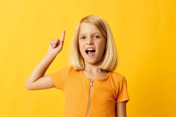 Cute little girl with blond hair based childhood yellow background — Zdjęcie stockowe