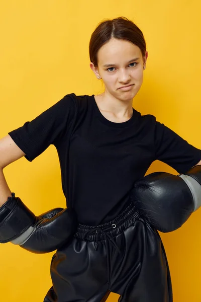 Jonge vrouw zwart bokshandschoenen poseren gele achtergrond sport — Stockfoto