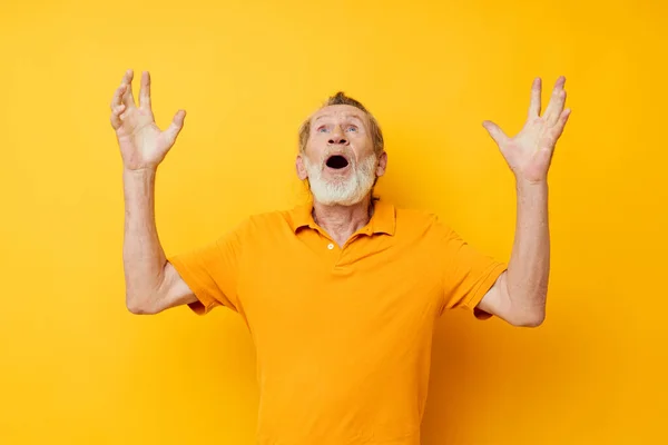 Starší šedovlasý muž s šedivými vousy emoce gesta ruce žluté pozadí — Stock fotografie