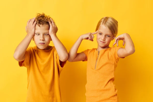 Портрет милых детей в желтых футболках, стоящих бок о бок детские эмоции желтый фон без изменений — стоковое фото
