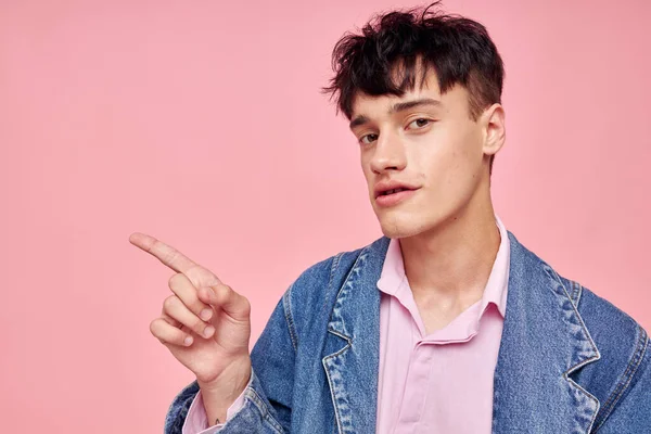 Un joven peinado de moda posando ropa chaqueta vaquera estilo moderno rosa fondo inalterado — Foto de Stock