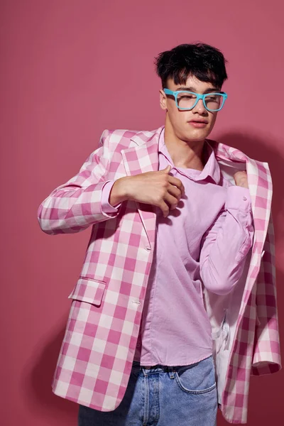 Portré egy fiatal férfi divatos szemüveg rózsaszín blézer pózol stúdió rózsaszín háttér változatlan — Stock Fotó