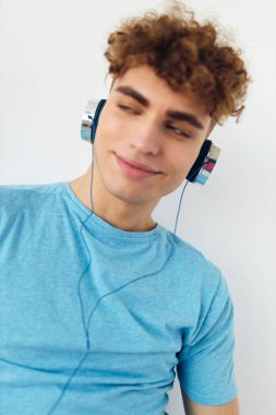 Kulaklık takan yakışıklı bir adam. Duyguları soyutlanmış.