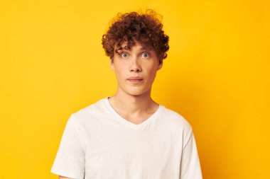 Sarı arka planda beyaz tişörtlü, kızıl saçlı adam.