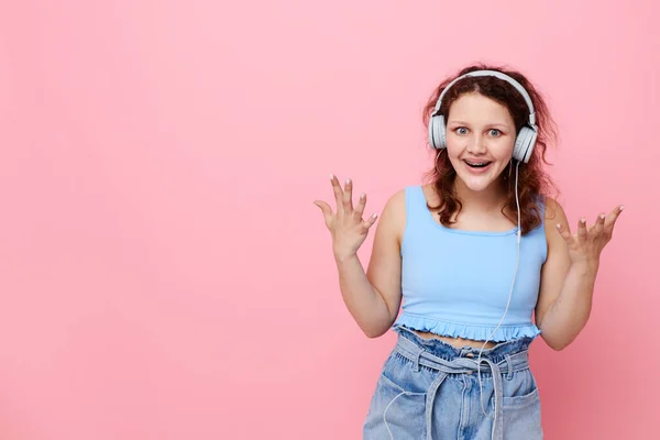 Χαρούμενο κορίτσι με ακουστικά σε στυλ νεολαίας θέτοντας ροζ φόντο αναλλοίωτο — Φωτογραφία Αρχείου
