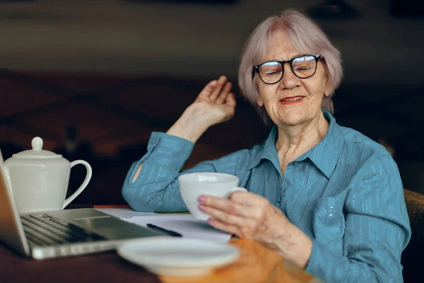 Anciana en un café una taza de bebida portátil Redes Sociales inalteradas — Foto de Stock