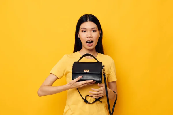 Kvinna med asiatiskt utseende i gula t-shirts mode poserar kvinnliga tillbehör Livsstil oförändrad — Stockfoto