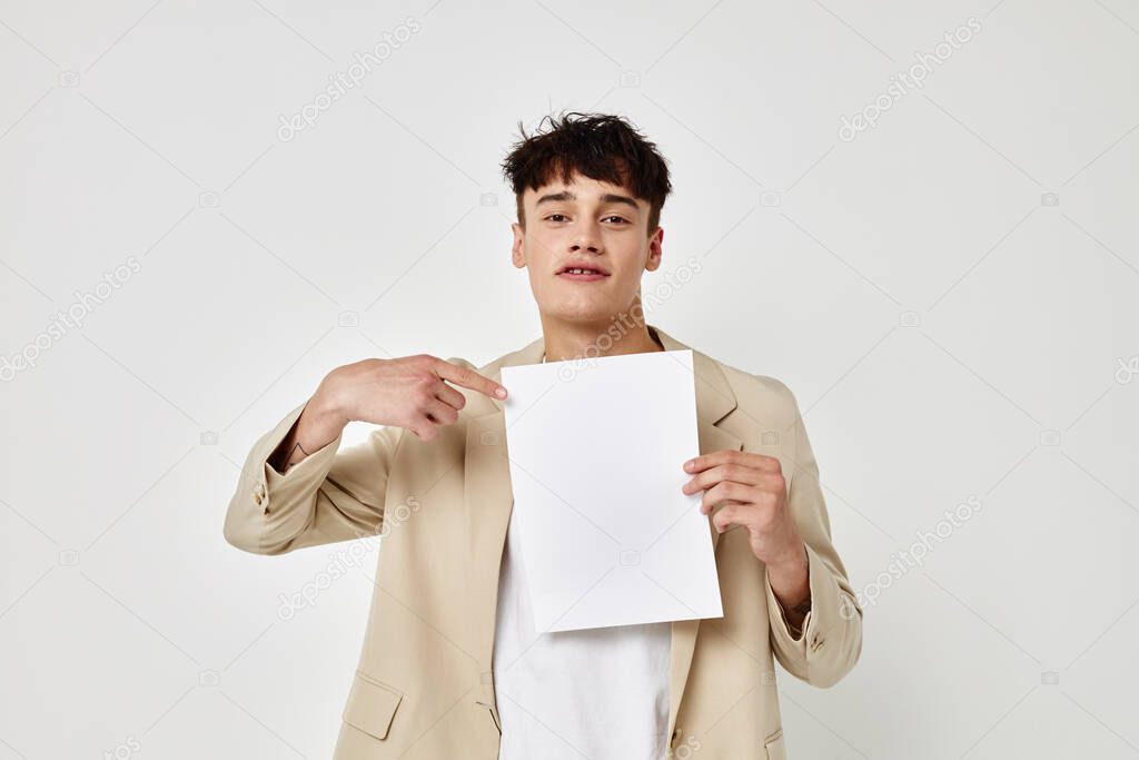 A young man in a beige suit copy-space folder with papers light background unaltered
