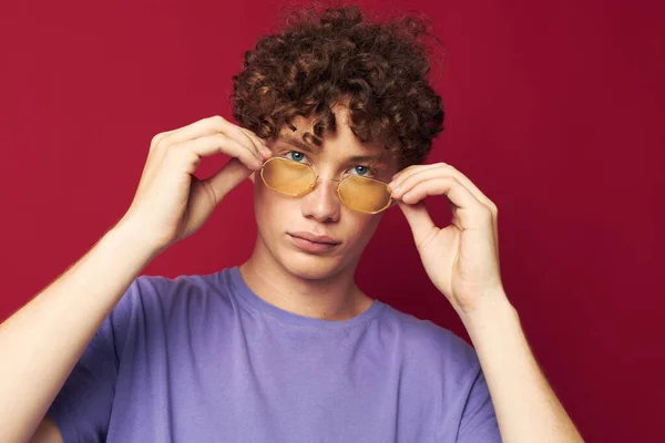 Portré egy fiatal göndör férfi sárga szemüvegben lila póló érzelmek Életmód — Stock Fotó