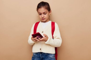 Çocukluğunda hiç değişmemiş sırt çantasıyla telefonda konuşan tatlı bir kız.