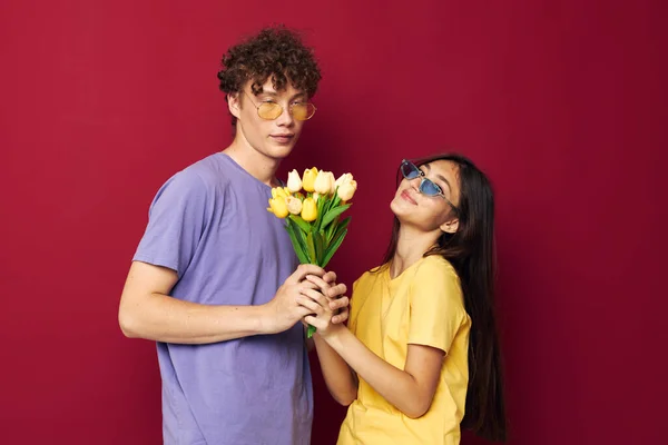 Roztomilý mladý pár kytice žlutých květin na základě přátelství pozadí beze změny — Stock fotografie