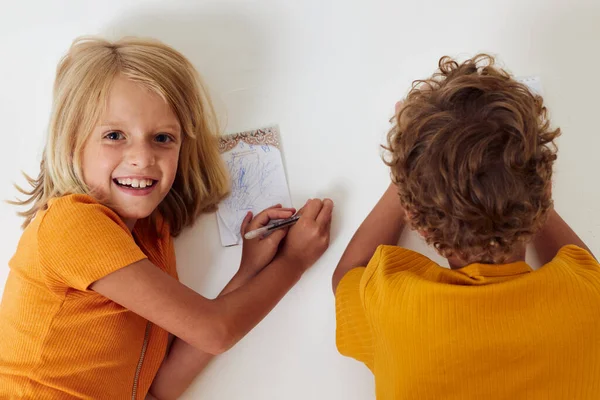 Kleine kinderen emoties samen te stellen notitieblok en potloden geïsoleerde achtergrond ongewijzigd — Stockfoto