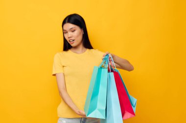 Asyalı görünümlü kadın moda alışverişi, soyutlanmış arka planda değişiklik yok.