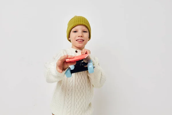Bambina in cappelli con uno skateboard nelle loro mani infanzia inalterata — Foto Stock