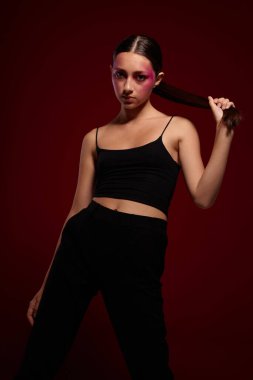 Seksi esmer kadın, el hareketleriyle lüks kozmetik ürünleri yapıyor.