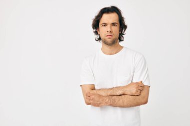 Beyaz tişörtlü yakışıklı adam telefonla iletişim kuruyor. Yaşam tarzı değişmemiş.