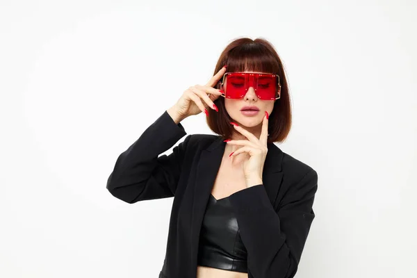 Vacker kvinna i en svart jacka röd nagellack mode glasögon ljus bakgrund — Stockfoto
