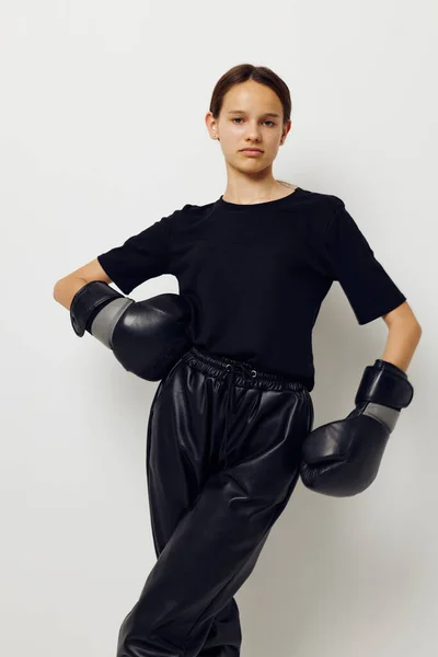 Young woman in boxing gloves in black pants and a T-shirt isolated background — 图库照片