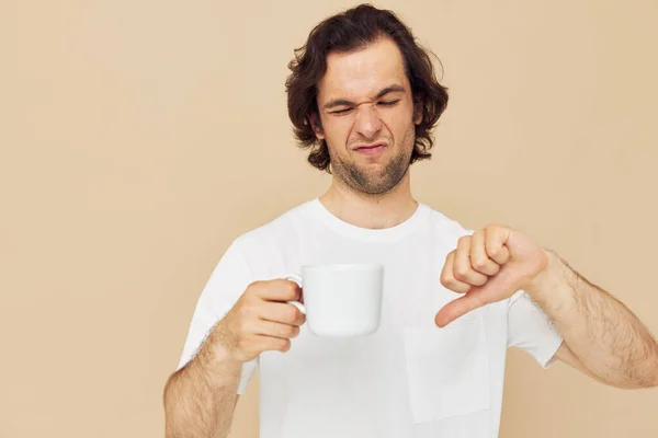Attractive man with a white mug in his hands emotions posing isolated background — Stock fotografie
