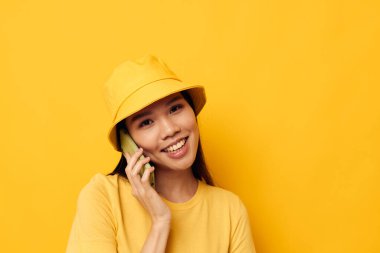 Sarı şapkalı ve tişörtlü güzel bir esmer telefon stüdyosu modelinde değişmeden konuşuyor.