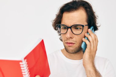 Beyaz tişörtlü çekici bir adam. Kırmızı not defteri. Yaşam tarzı değişmemiş.