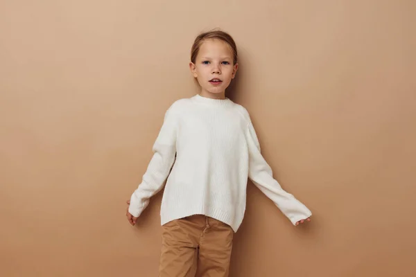 Retrato de niña sonriente feliz en suéter blanco posando gestos de la mano infancia inalterada — Foto de Stock