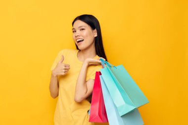 El alışverişinde paketleri olan Asyalı güzel kadın portresi. Değişmemiş yaşam tarzı.