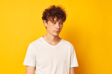 Sarı arka planda beyaz tişörtlü, kızıl saçlı adam.