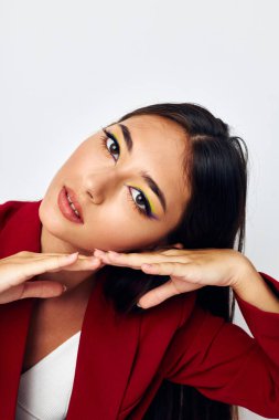 Güzel esmer, parlak makyajlı, kırmızı ceketli. Stüdyo modelini değiştirmemiş.