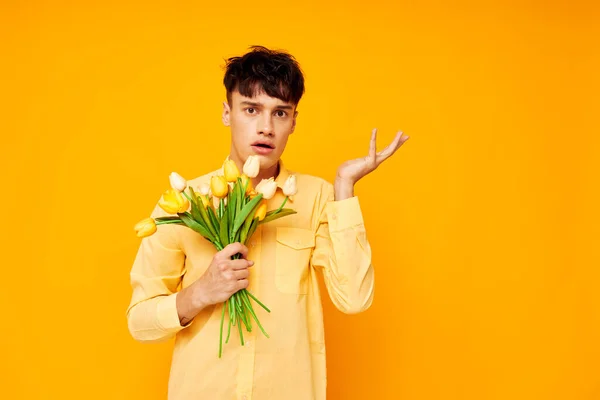 Cara bonito com um penteado elegante em camisas amarelas com flores fundo amarelo inalterado — Fotografia de Stock