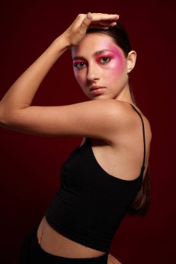 Genç, güzel bir kadın. Siyah tişört. Pembe makyaj.