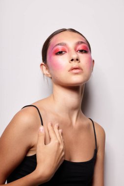 Moda duyguları pozu veren parlak makyajlı şık bir kadın. Arka planda değişiklik yok.