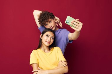 Genç adam ve kız, izole edilmiş bir arka planda selfie çekiyorlar.