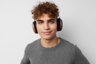 Kulaklıkla müzik dinleyen şık bir adam. Duyguları hafif arka planda.